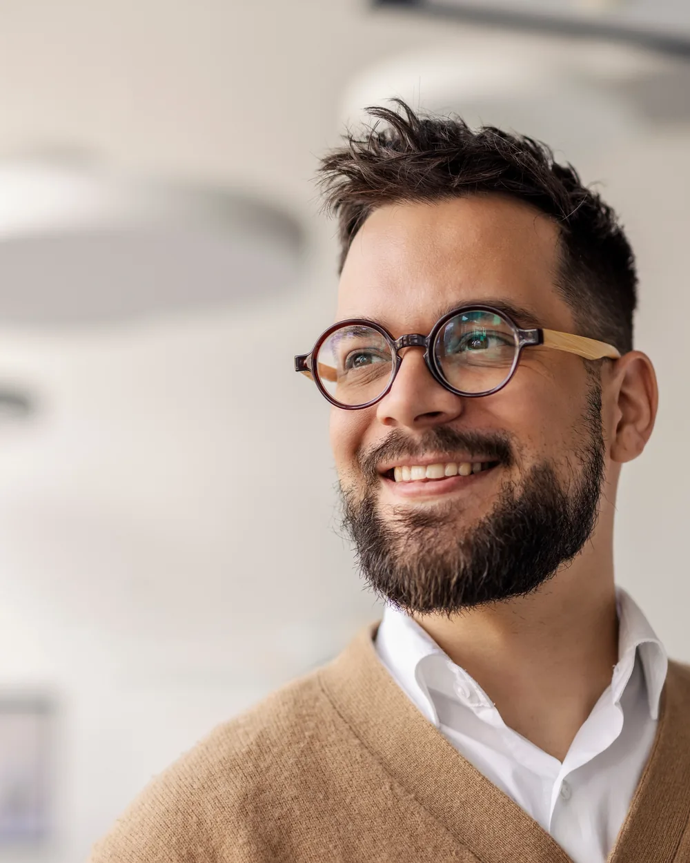 Smiling man in glasses in a bright hallway