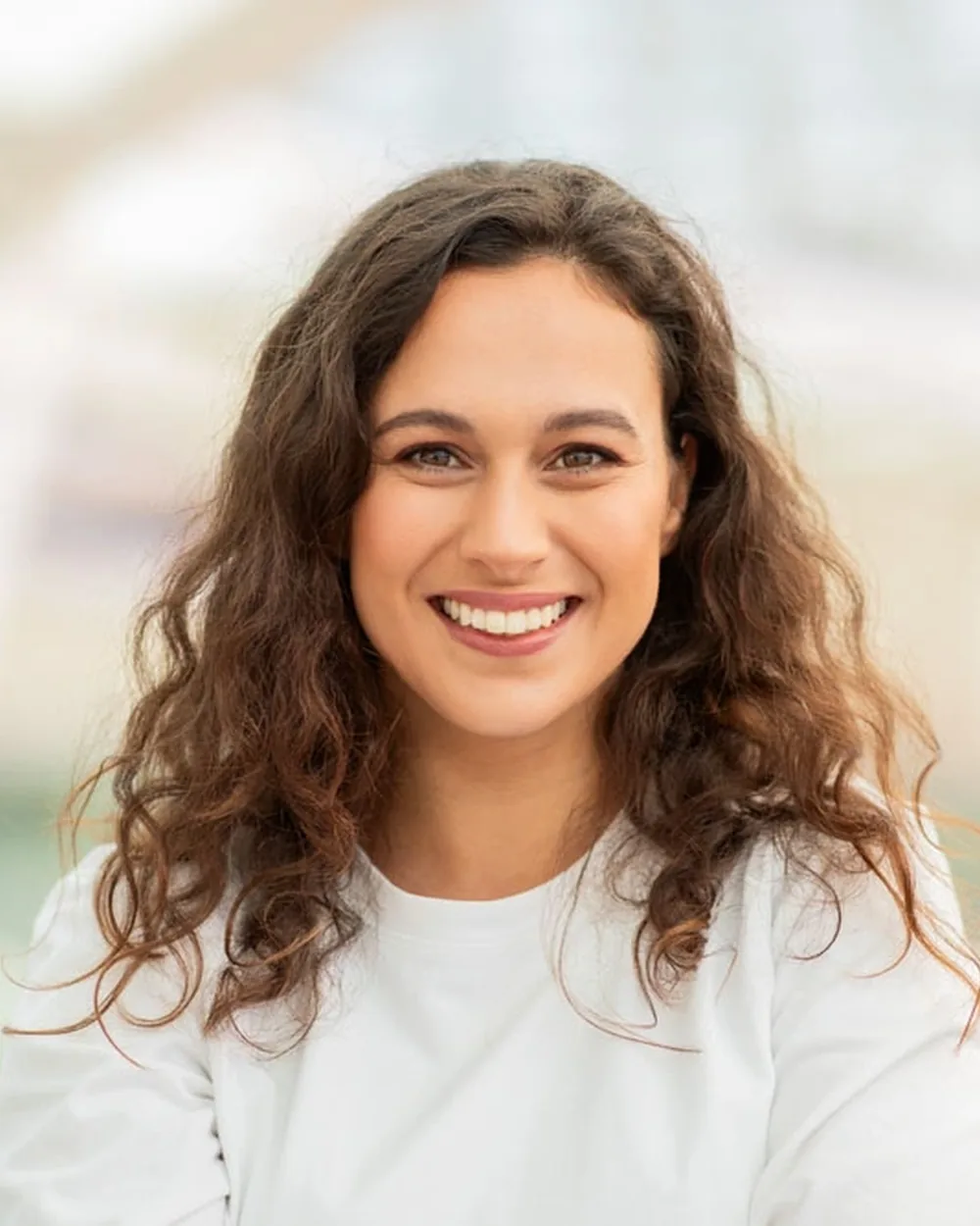 Smiling woman in a white top with a natural-looking smile