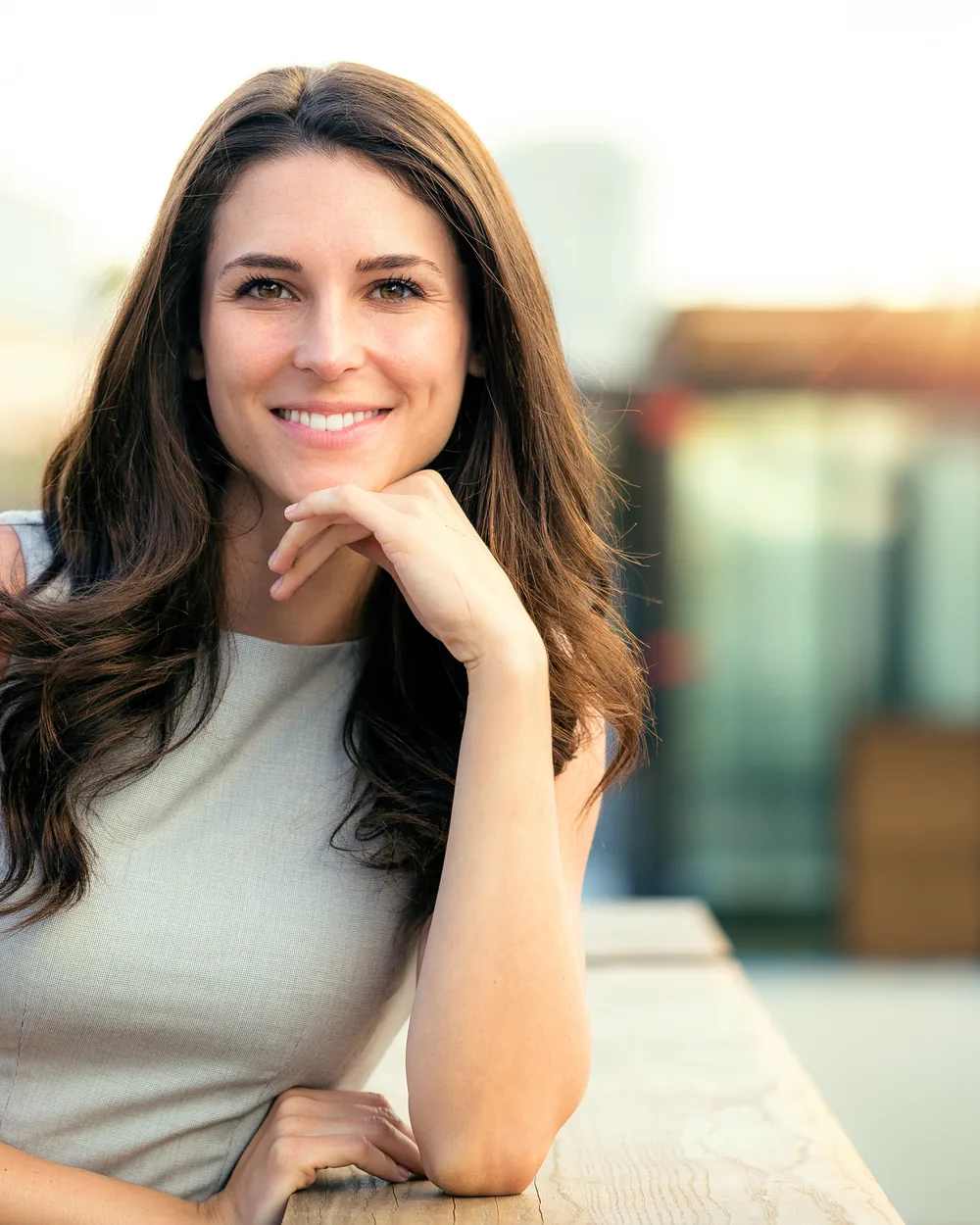 Smiling woman seated outdoors in soft sunlight