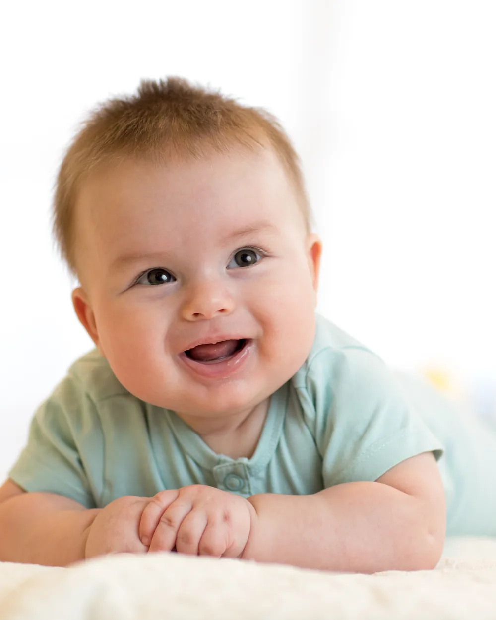 Smiling baby lying on a soft blanket