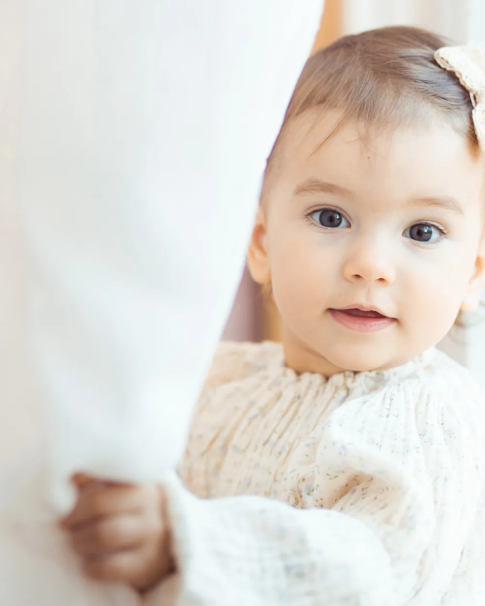 Baby smiling beside a bright window