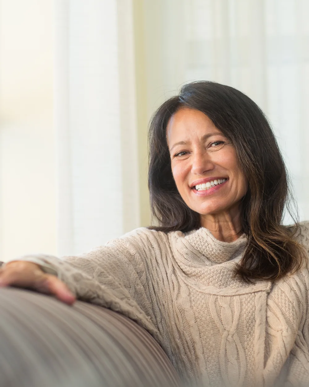 Relaxed woman seated on a sofa with a mug