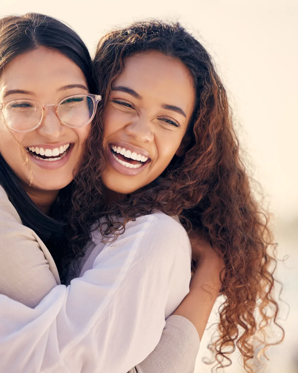 Two smiling women in bright natural light
